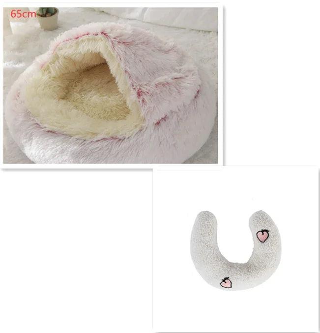 Plush pink cat or small dog cave bed with soft interior and a matching white U-shaped pillow.