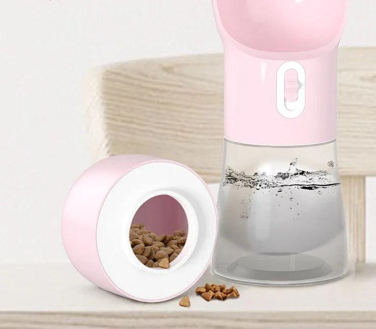Pink portable pet water bottle and food container with kibble and water, on a light surface
