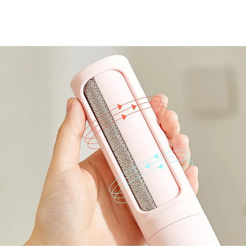 Hand holding pink pet hair remover roller with textured surface for dogs and cats