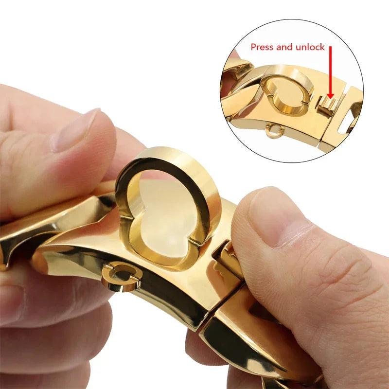 Close-up of hands unlocking a gold stainless steel dog chain collar with quick-release clasp.