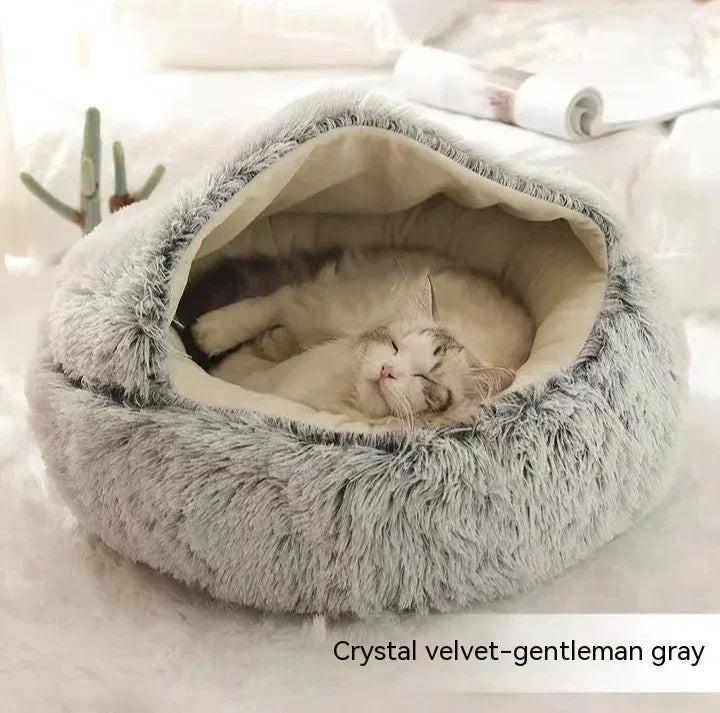 Cat sleeping in cozy gray crystal velvet pet cave bed indoors