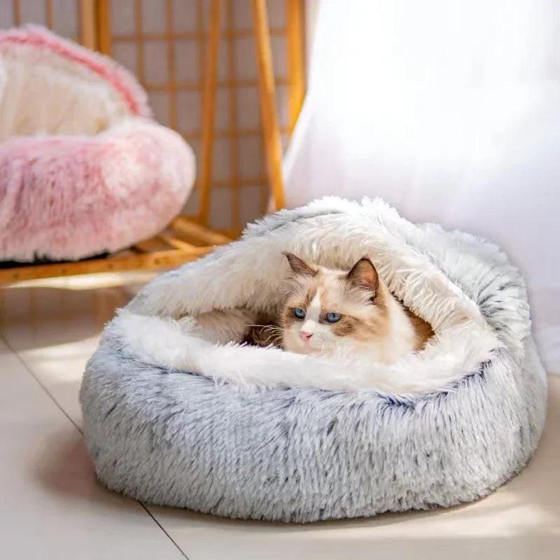 Long-haired cat lying in a plush, cozy, gray faux fur cat cave bed indoors