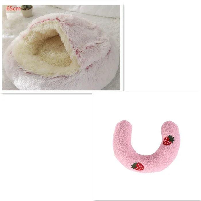 Fluffy pink pet bed with hooded cover and pink U-shaped pillow decorated with strawberries.