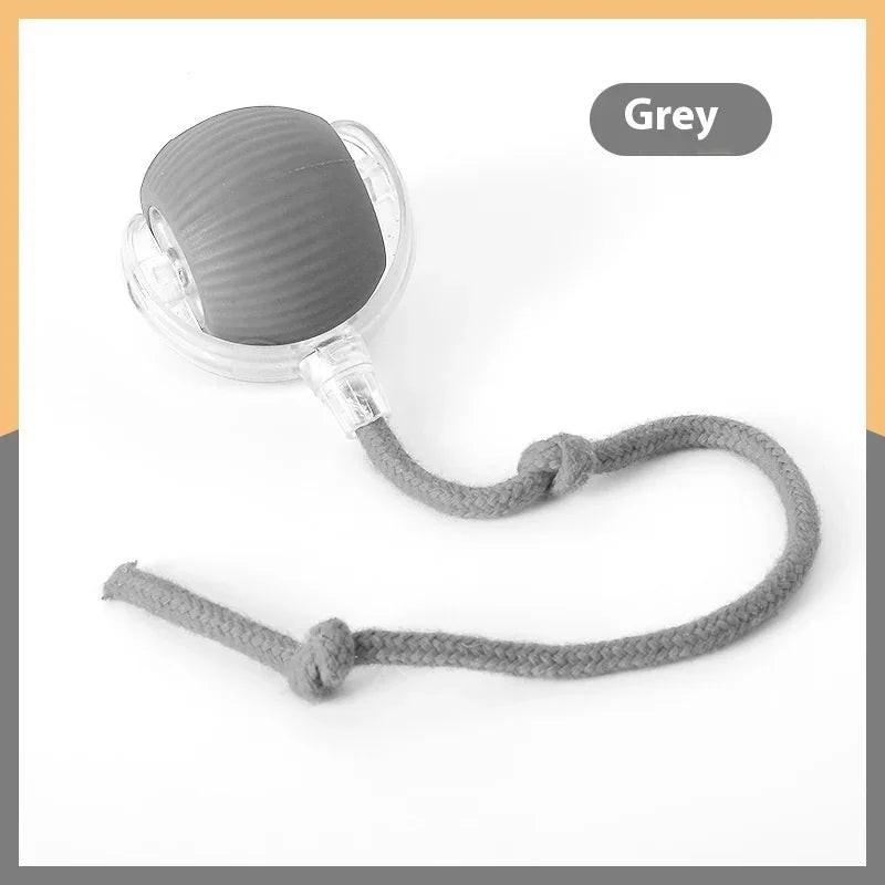 Grey cat toy ball with textured surface, clear plastic base, and attached braided rope.