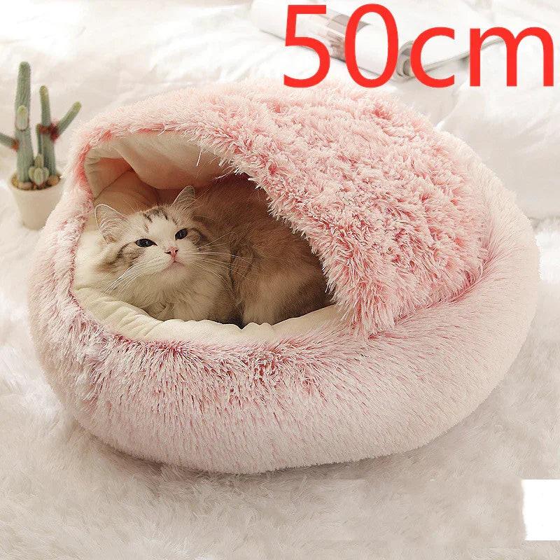 Cat resting in a pink fluffy covered pet bed, 50cm size, on a soft white rug