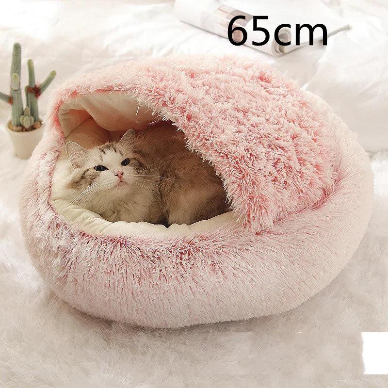 Fluffy cat resting in pink 65cm covered pet bed on a soft white carpet
