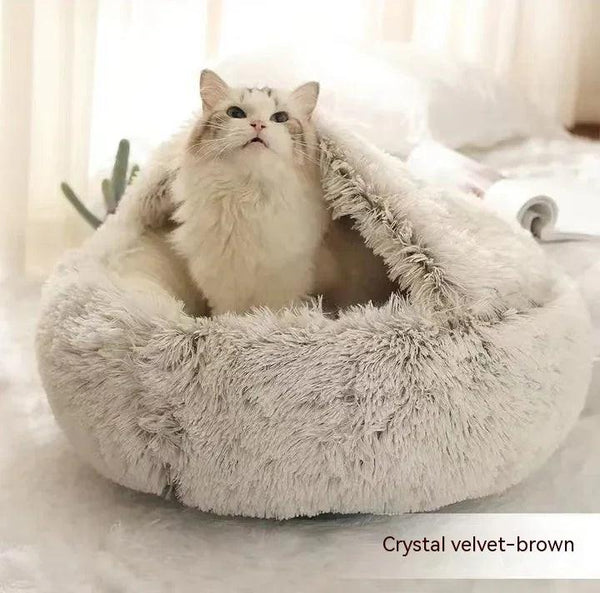 Fluffy white cat in a soft crystal velvet brown covered cat bed on a cozy indoor surface