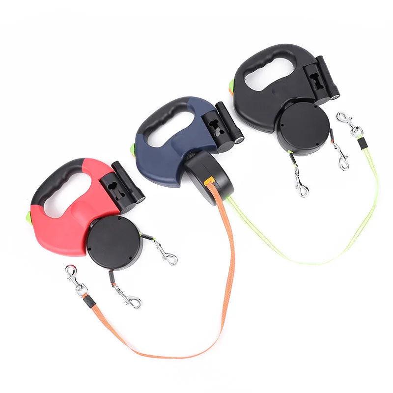 Three retractable dual dog leashes with ergonomic handles in red, blue, and black on white background