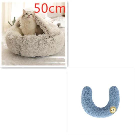 White fluffy cat in a cozy 50cm plush pet bed and a blue U-shaped pet pillow with lion patch.