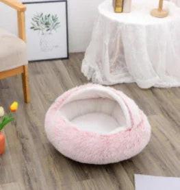 Soft pink fluffy pet bed with canopy on wooden floor in cozy living room
