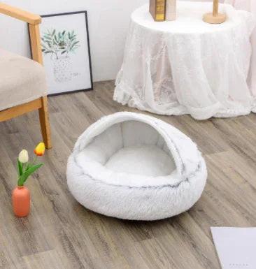 Cozy white hooded pet bed for dogs or cats in a modern living room with wood flooring