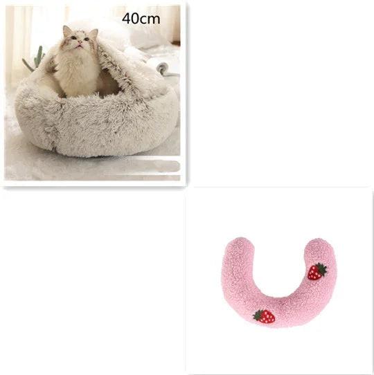 Fluffy cat in a soft cave pet bed, and a pink plush U-shaped pillow with strawberry accents.